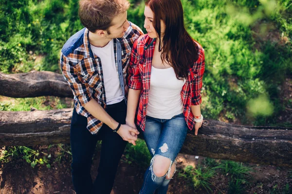 Schönes Paar sitzt im Hintergrund des Parks — Stockfoto