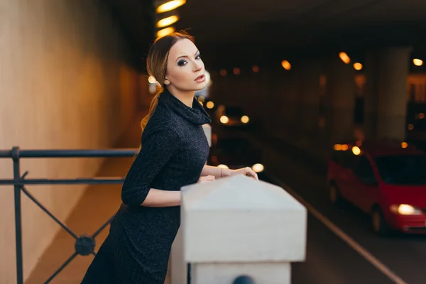 Mujer joven de pie en la calle con luces — Foto de Stock