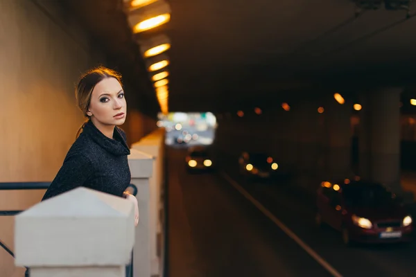 Giovane donna in piedi sulla strada con le luci — Foto Stock