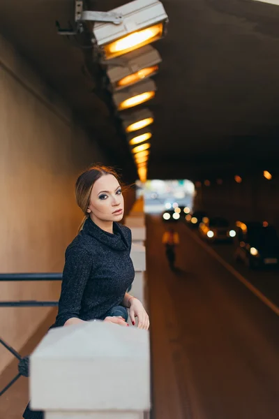 Mujer joven de pie en la calle con luces — Foto de Stock