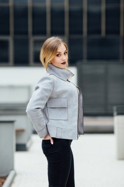 Ofis binaları önünde duran genç kadın