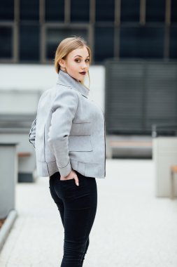 Ofis binaları önünde duran genç kadın