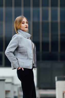 Ofis binaları önünde duran genç kadın