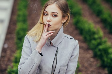 Genç kadın duman sigara bankta