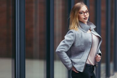 Ofis binaları önünde duran genç kadın