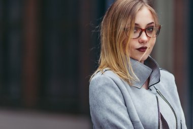 Ofis binaları önünde duran genç kadın