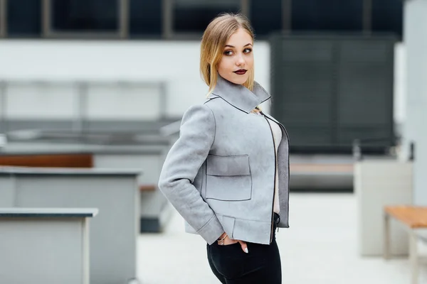 Ung kvinna står framför kontorsbyggnader — Stockfoto
