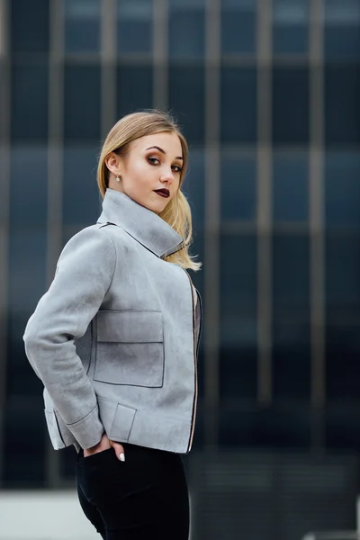 Young woman standing in front of office buildings — Stock Photo, Image