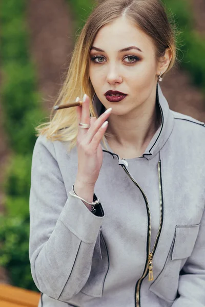 Jeune femme fumant de la cigarette sur le banc — Photo