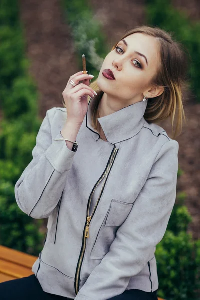 Giovane donna fumare sigaretta sulla panchina — Foto Stock