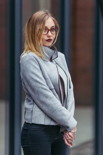 Jovem mulher em pé na frente de edifícios de escritórios — Fotografia de Stock
