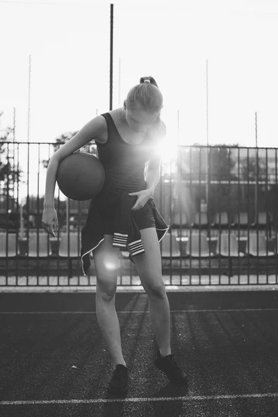 Deportiva chica de pie con pelota de baloncesto — Foto de Stock