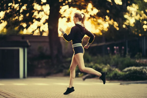 Chica bonita corriendo en el fondo del parque — Foto de Stock