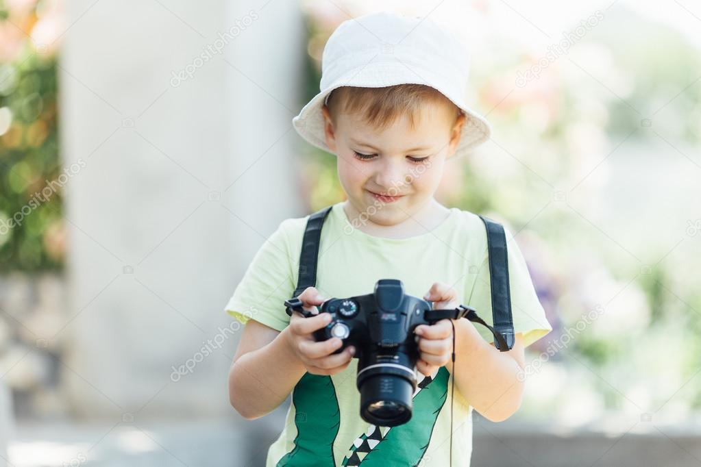 Young boy taking photos of beautiful summer background