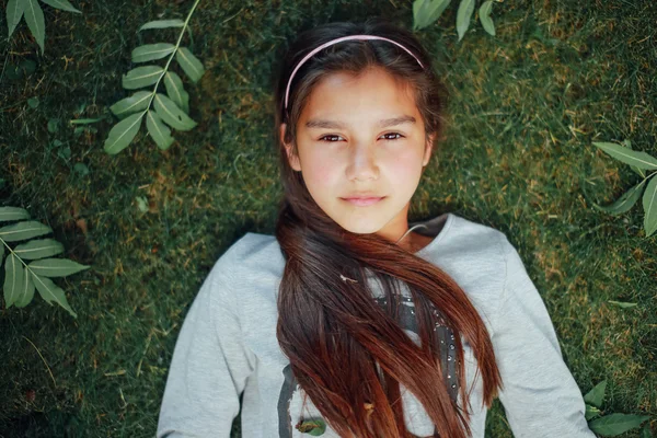 Menina bonita deitada na grama e sorrir — Fotografia de Stock