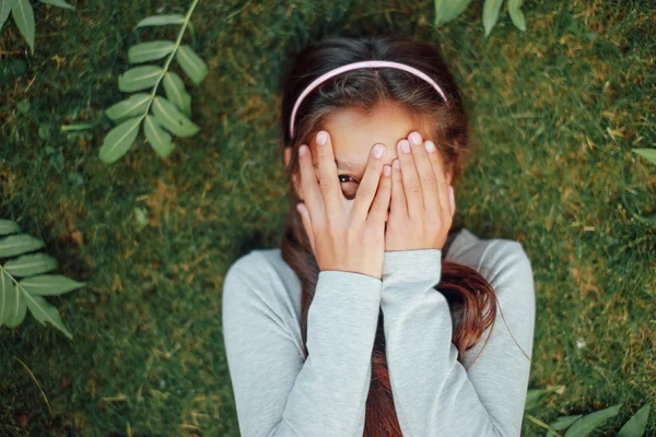 Belle petite fille allongée sur l'herbe et sourire — Photo