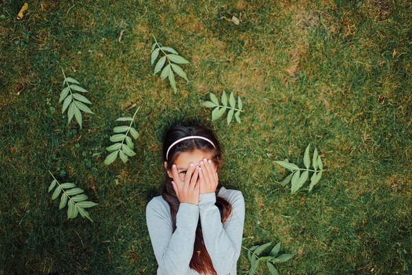 Belle petite fille allongée sur l'herbe et sourire — Photo