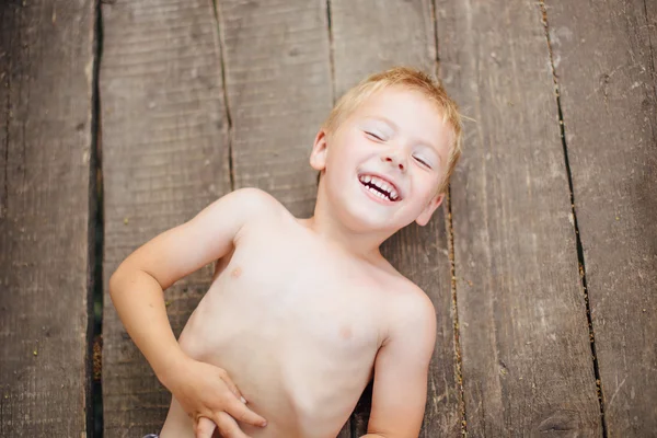 地面と笑顔の上に横たわる美しい少年 — ストック写真