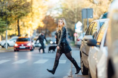 Arabalar sokakta yürüyen genç ve güzel kadın