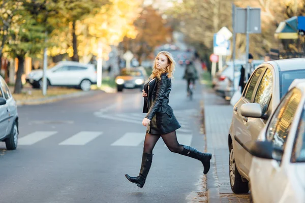 Jolie jeune femme marchant dans la rue avec des voitures — Photo