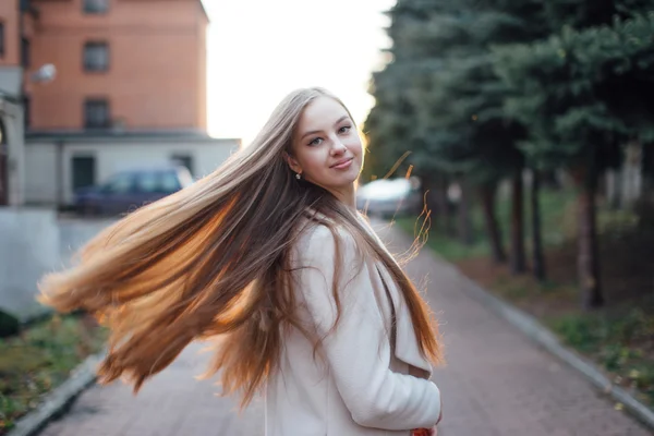 Tjej med mycket långt hår på sunset bakgrunden — Stockfoto