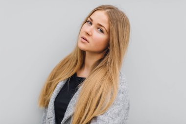 Duvarın arkasında duran ve ti kamera poz sarışın genç kadın