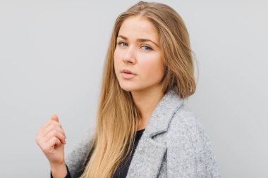 Duvarın arkasında duran ve ti kamera poz sarışın genç kadın