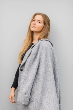 Duvarın arkasında duran ve ti kamera poz sarışın genç kadın