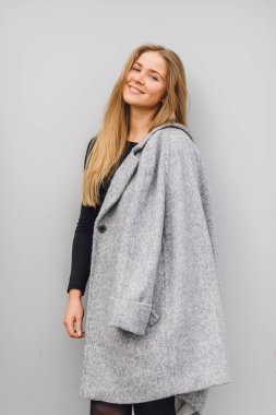 Duvarın arkasında duran ve ti kamera poz sarışın genç kadın