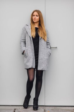 Duvarın arkasında duran ve ti kamera poz sarışın genç kadın