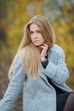 Gülümseme ve tezgah üzerinde oturan sarışın kadın