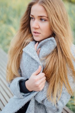 Gülümseme ve tezgah üzerinde oturan sarışın kadın