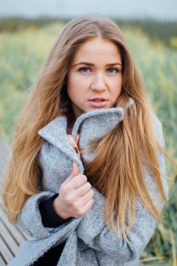 Gülümseme ve tezgah üzerinde oturan sarışın kadın