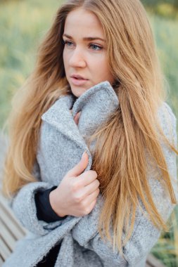 Gülümseme ve tezgah üzerinde oturan sarışın kadın