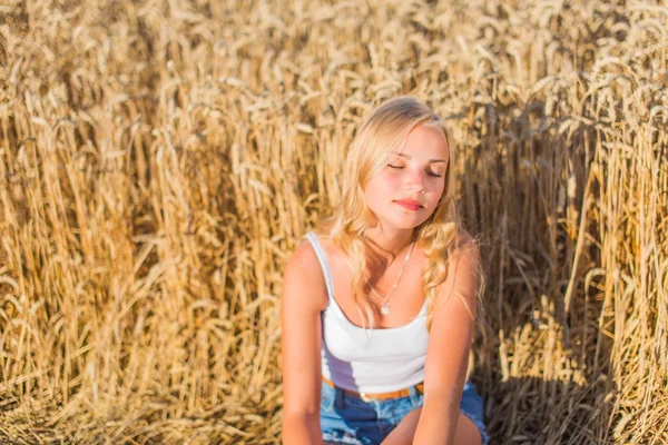 Fiatal lány mosolyogva területén, naplemente, nyári idő — Stock Fotó