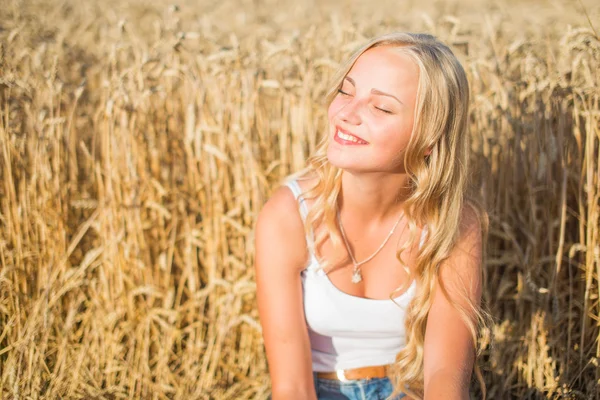 Fiatal lány mosolyogva területén, naplemente, nyári idő — Stock Fotó