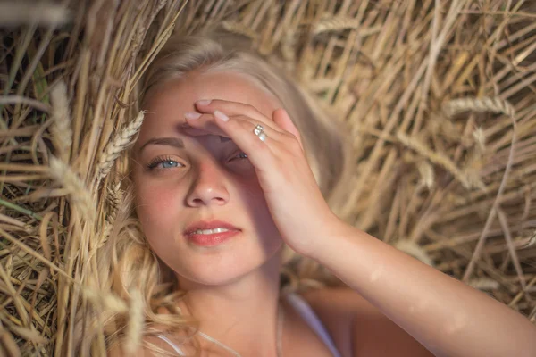 Chica joven está sonriendo en el campo, puesta de sol, hora de verano —  Fotos de Stock