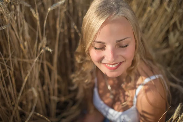 Chica joven está sonriendo en el campo, puesta de sol, hora de verano —  Fotos de Stock