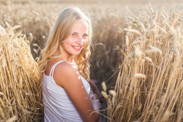 Chica joven está sonriendo en el campo, puesta de sol, hora de verano —  Fotos de Stock
