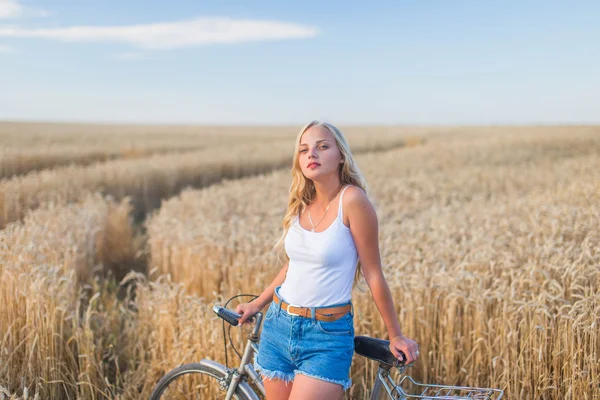 Девушка улыбается в поле, на закате, в летнее время — стоковое фото