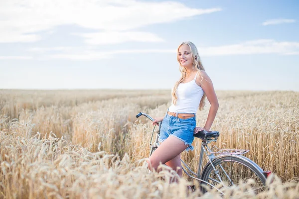 Девушка улыбается в поле, на закате, в летнее время — стоковое фото