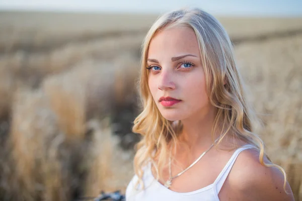 Chica joven está sonriendo en el campo, puesta de sol, hora de verano — Foto de Stock