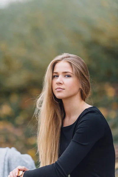 Rubia mujer de pelo sentado en el banco y sonrisa — Foto de Stock