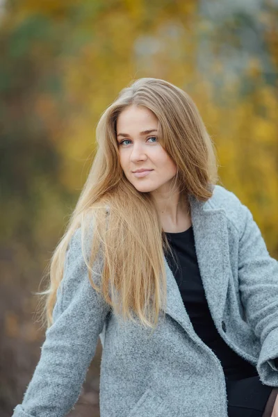 Bionda capelli donna seduta sulla panchina e sorridere — Foto Stock