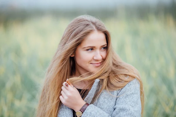 Rubia mujer de pelo sentado en el banco y sonrisa — Foto de Stock