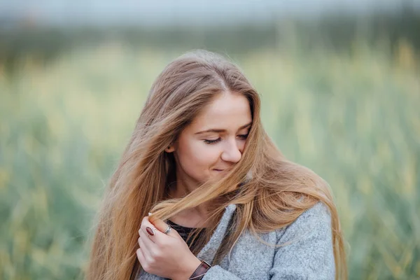 Rubia mujer de pelo sentado en el banco y sonrisa — Foto de Stock