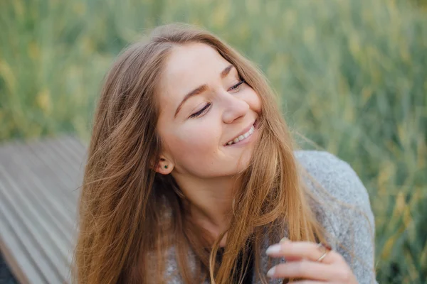 Rubia mujer de pelo sentado en el banco y sonrisa —  Fotos de Stock