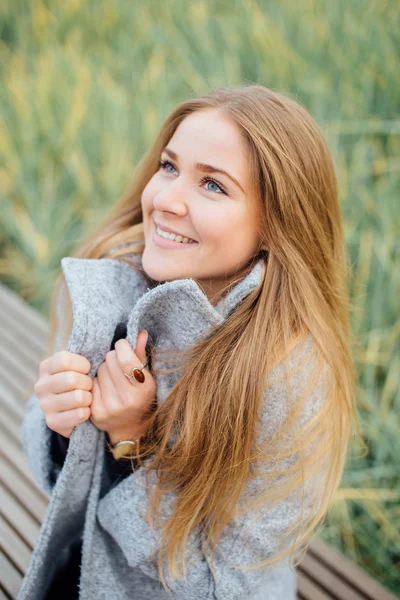 Szőke haj nő ül a padon, és mosoly — Stock Fotó