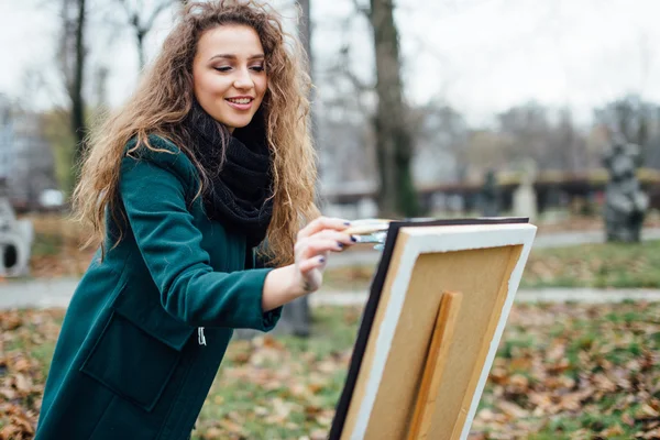 Jeune femme dessinant dans le chevalet sur le fond du parc — Photo