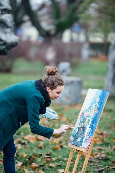 Jeune femme dessinant dans le chevalet sur le fond du parc — Photo